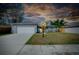 Inviting home with a well-lit exterior and landscaped yard at twilight at 4068 Palau Dr, Sarasota, FL 34241