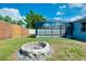 Charming backyard showcasing a stone fire pit and a screened-in pool area, perfect for outdoor entertaining and relaxation at 4068 Palau Dr, Sarasota, FL 34241