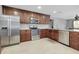 Spacious kitchen with stainless steel appliances, granite countertops, and dark wood cabinets and light tile flooring at 4068 Palau Dr, Sarasota, FL 34241