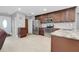 Large kitchen with stainless steel appliances, granite countertops, and dark wood cabinets and light tile flooring at 4068 Palau Dr, Sarasota, FL 34241