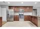 Well-lit kitchen with stainless steel appliances, granite countertops, and dark wood cabinets and light tile flooring at 4068 Palau Dr, Sarasota, FL 34241