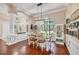 Elegant dining room with hardwood floors, stylish lighting, and a large window overlooking the front yard at 4305 Sandune Ave, North Port, FL 34287
