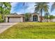 Lovely single-Gathering home featuring a well-manicured lawn, palm trees, and an American flag at 4305 Sandune Ave, North Port, FL 34287
