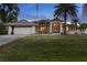 Attractive single-Gathering home with a lush green lawn, palm trees, and an inviting front entrance at 4305 Sandune Ave, North Port, FL 34287