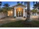 Inviting front entrance illuminated with landscape lighting and decorative flower pots on the entryway at 4305 Sandune Ave, North Port, FL 34287