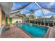 A screened pool with brick-paved deck, lovely water feature, and tropical surroundings at 4305 Sandune Ave, North Port, FL 34287