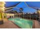 Enclosed pool area with overhead lights, patio, and serene backyard views at 4305 Sandune Ave, North Port, FL 34287