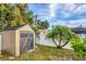 Durable backyard shed provides extra storage, complemented by lush landscaping and a privacy fence at 4305 Sandune Ave, North Port, FL 34287