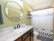This bath has a round mirror and a shower with decorative curtains at 4835 San Ortebello Dr, Bradenton, FL 34208