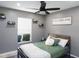 Cozy bedroom with a ceiling fan, floating shelves, and a window at 4835 San Ortebello Dr, Bradenton, FL 34208
