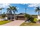 Beautiful home featuring a brick paved driveway, tropical landscaping, and a brown two-car garage door at 4835 San Ortebello Dr, Bradenton, FL 34208