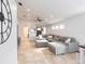 Bright living room featuring tile flooring, neutral paint, gray sectional sofa, and modern ceiling fan at 4835 San Ortebello Dr, Bradenton, FL 34208