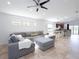 Bright living room boasts tile flooring, neutral paint, gray sectional sofa, and connects to the kitchen at 4835 San Ortebello Dr, Bradenton, FL 34208