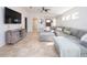 Cozy living room featuring tile flooring, modern ceiling fan, a comfortable gray sectional sofa, and a TV at 4835 San Ortebello Dr, Bradenton, FL 34208