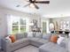 Spacious living area with a large sectional sofa, a ceiling fan, and abundant natural light at 4907 Wedgeleaf Way, Palmetto, FL 34221