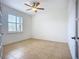 Bright bedroom featuring a ceiling fan, plantation shutters, and tile flooring at 5384 Layton Dr, Venice, FL 34293