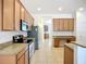 Well-lit kitchen with granite counters, stainless steel appliances and adjacent bonus space at 5384 Layton Dr, Venice, FL 34293