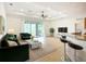 Cozy living room with a ceiling fan, sliding doors to lanai and a view into the kitchen at 5384 Layton Dr, Venice, FL 34293