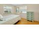 This is a cozy bedroom with wood floors, windows, and a green dresser at 595 Circlewood Dr # Y4, Venice, FL 34293