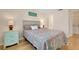 Colorful bedroom with hardwood floors, bright comforter, and side tables with lamps at 595 Circlewood Dr # Y4, Venice, FL 34293