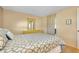 Well-lit bedroom with blue and white patterned comforter and a wooden dresser at 595 Circlewood Dr # Y4, Venice, FL 34293