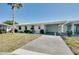 Bright single-story home with a carport, fresh white paint, yellow shutters, and a neatly kept lawn at 595 Circlewood Dr # Y4, Venice, FL 34293