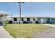 Bright single-story home featuring white exterior, yellow shutters, front lawn, and attached carport at 595 Circlewood Dr # Y4, Venice, FL 34293