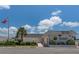 Daytime exterior view of a Circle Woods Clubhouse with American flag and mature landscaping at 595 Circlewood Dr # Y4, Venice, FL 34293
