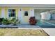 Inviting home entrance with yellow door, window shutters, and tidy landscaping at 595 Circlewood Dr # Y4, Venice, FL 34293