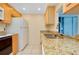 Bright kitchen featuring granite countertops, a sink, and an adjacent refrigerator at 595 Circlewood Dr # Y4, Venice, FL 34293