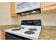 Electric range and microwave oven in a cozy kitchen with bright, natural-colored cabinetry at 595 Circlewood Dr # Y4, Venice, FL 34293