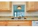 Well-appointed kitchen area featuring stainless steel sink, granite countertops, and natural cabinetry at 595 Circlewood Dr # Y4, Venice, FL 34293