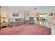 Spacious living room with pink carpet, connecting to a dining area and kitchen, perfect for entertaining at 595 Circlewood Dr # Y4, Venice, FL 34293