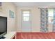 Cozy living room with a white door, blue floral curtains, and pink carpet at 595 Circlewood Dr # Y4, Venice, FL 34293