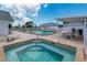 A luxurious community pool and hot tub with lounge chairs and a shaded seating area, perfect for relaxation at 595 Circlewood Dr # Y4, Venice, FL 34293