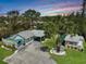 This aerial view showcases the home's layout, landscaping, multiple outdoor living spaces and the surrounding lush greenery at 810 Channel Acres Rd, Nokomis, FL 34275