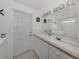 Clean, bright bathroom with large mirror, updated vanity, and tile flooring at 8132 Coco Solo Ave, North Port, FL 34287