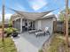 Back patio featuring a sunshade, lounge chairs, and access to the screened-in lanai at 8132 Coco Solo Ave, North Port, FL 34287