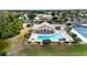 Aerial view of community pool, clubhouse, tennis courts, and lush landscaping at 8300 Parkside Dr, Englewood, FL 34224