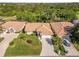 A sunny aerial view shows a terracotta-roofed home with lush landscaping in a well-maintained neighborhood at 8300 Parkside Dr, Englewood, FL 34224
