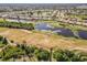 Aerial shot featuring a golf course alongside serene bodies of water in a planned community at 8300 Parkside Dr, Englewood, FL 34224