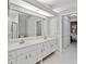 Bright bathroom featuring double sinks, white cabinets, and a large mirror at 8300 Parkside Dr, Englewood, FL 34224