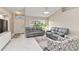 Bright living room with white tile flooring, neutral walls, and comfortable gray leather seating at 8300 Parkside Dr, Englewood, FL 34224