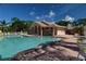 Community pool and clubhouse with plenty of seating and beautiful landscaping at 8300 Parkside Dr, Englewood, FL 34224