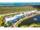 Aerial view of condominiums with a lake and fountain, adjacent to a road and natural wetlands at 8405 Placida Rd # 206, Placida, FL 33946