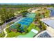 Aerial view of the tennis courts surrounded by lush tropical landscaping and the coastline in the background at 8405 Placida Rd # 206, Placida, FL 33946