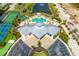 Aerial view of the clubhouse, pool, tennis courts, and parking lot surrounded by lush tropical landscaping at 8405 Placida Rd # 206, Placida, FL 33946