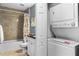 Functional bathroom with a shower-tub combo and a convenient stacked washer and dryer unit at 8405 Placida Rd # 206, Placida, FL 33946