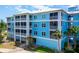 Exterior view of condo building with screened in balconies and a tropical landscape, offering serene views at 8405 Placida Rd # 206, Placida, FL 33946