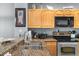 Kitchen featuring granite counters, a stainless steel oven, and light wood cabinets at 8405 Placida Rd # 206, Placida, FL 33946